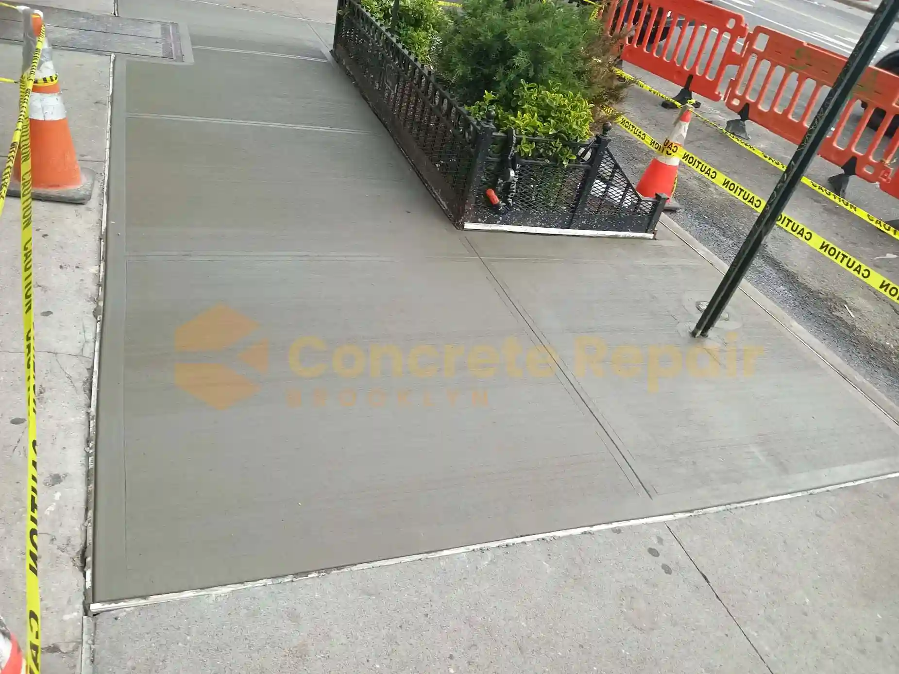 A man is on a sidewalk near a construction site, observing the ongoing concrete resurfacing project.